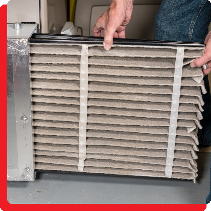 a person replacing a furnace filter
